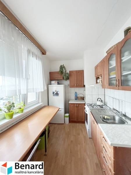 Küche in einer 2-Zimmer-Wohnung mit einem Gasherd und Holzmöbeln.