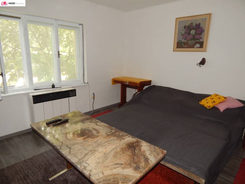 Die Hütte bietet ein gemütliches Schlafzimmer mit einem Doppelbett, einem Tisch und einem Sessel.