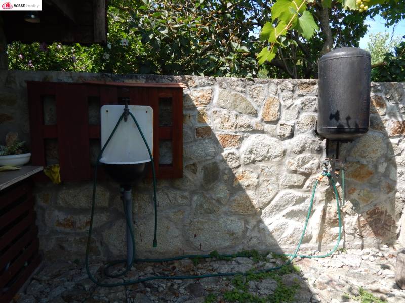 Steinmauer in Klížska Nemá mit Waschbecken und Tank bei der Hütte.