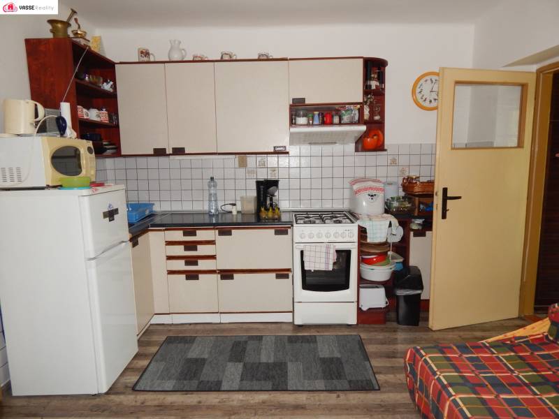 Küche in einer Hütte mit Holzboden, Schränken und Geräten.