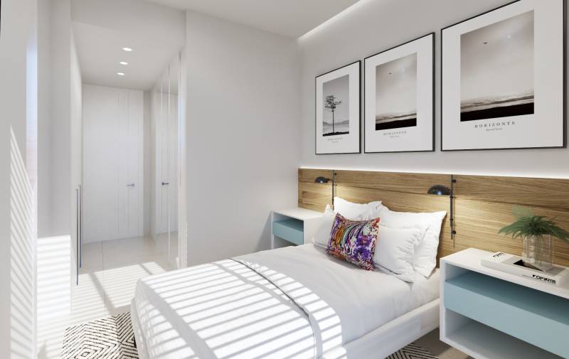 Helles Schlafzimmer in einer 3-Zimmer-Wohnung mit weißen Möbeln und dekorativen Bildern an der Wand.