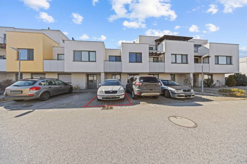 Auf der Mondstraße sieht man einen Parkplatz vor Reihenhäusern und eine Außenwohnung mit 2 Zimmern.