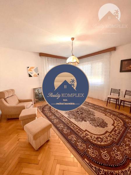 Wohnzimmer in einem Einfamilienhaus, Sessel, Teppich mit Ornamenten und Hängelampe.