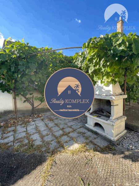 Ein Garten bei einem Einfamilienhaus in Veľké Blahovo mit Weinreben und einem Außenkamin.