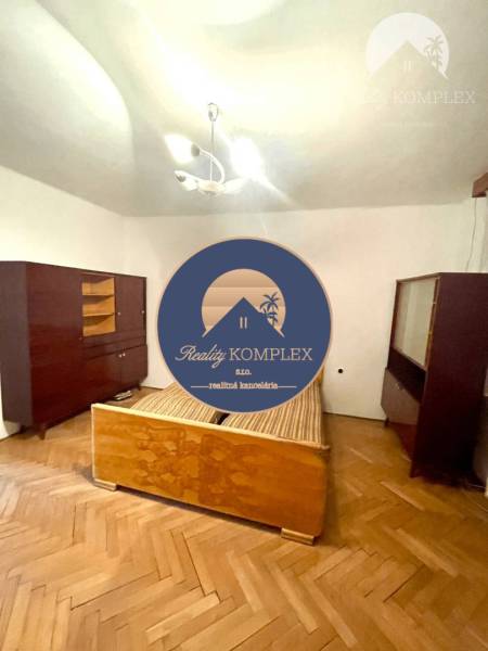 Schlafzimmer in einem Einfamilienhaus mit älteren Möbeln und Holzboden.