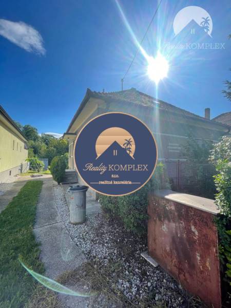 Ein Einfamilienhaus in Veľké Blahovo mit Zufahrtsstraße und Garten unter klarem Sonnenschein.