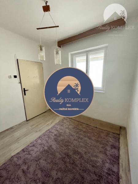 Zimmer in einem Einfamilienhaus, helles Interieur, Holzbalken, Kronleuchter, violetter Teppich.