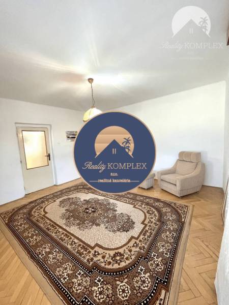 Wohnzimmer in einem Einfamilienhaus mit Teppich und Sessel.