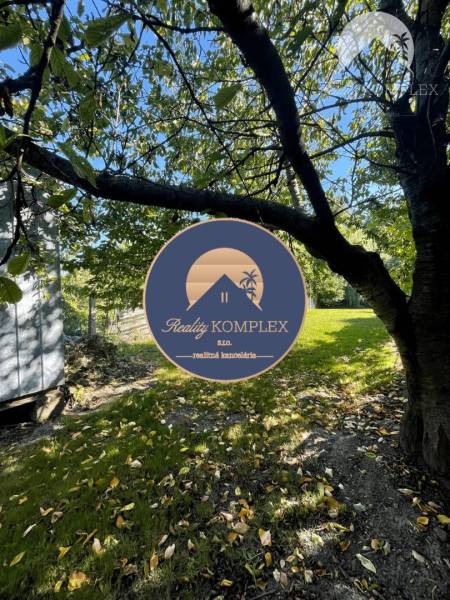 Der Garten des Einfamilienhauses in Veľké Blahovo, umgeben von Bäumen und Grün.