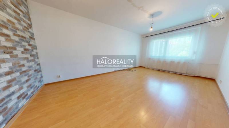 Ein Zimmer mit Holzboden und Ziegelwand in einer 4-Zimmer-Wohnung.