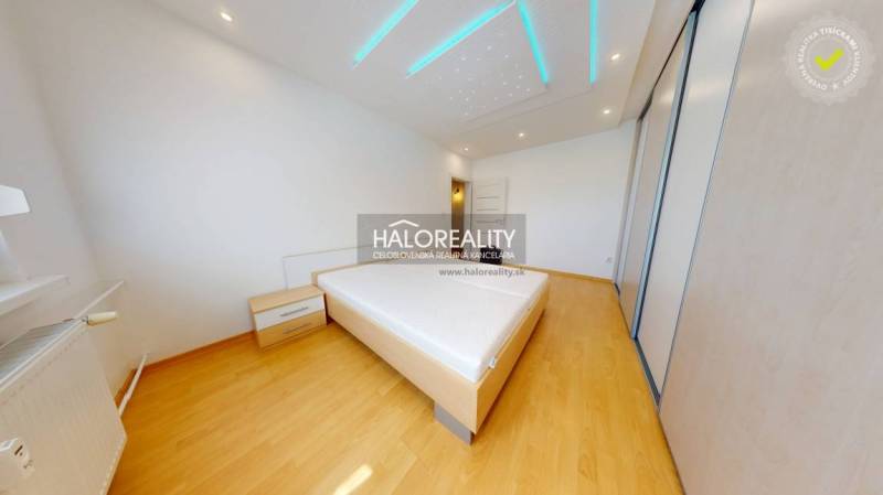 Schlafzimmer in einer 4-Zimmer-Wohnung mit Holzboden und Bett.