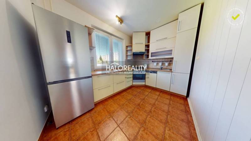 Küche in einer 4-Zimmer-Wohnung mit moderner Küchenzeile und Kühlschrank.