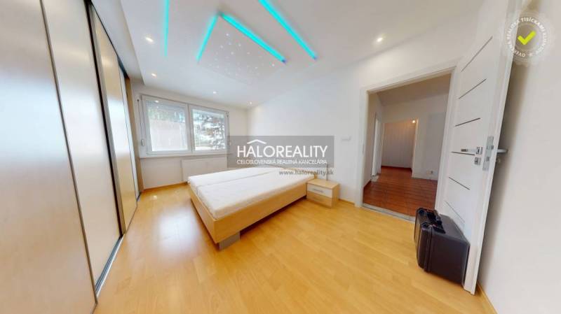 Schlafzimmer in einer 4-Zimmer-Wohnung mit Bett, Einbauschrank und LED-Beleuchtung.