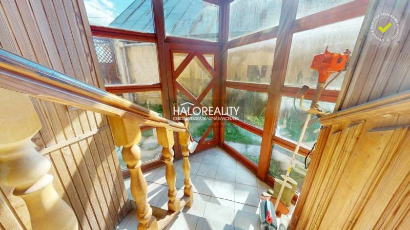 Eine Holztreppe mit verglasten Wänden in einem Einfamilienhaus, ausgestattet mit Gartengeräten.