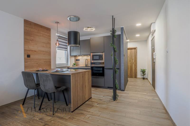 Stilvolle Küche in einer 3-Zimmer-Wohnung mit Holz- und grauen Akzenten.