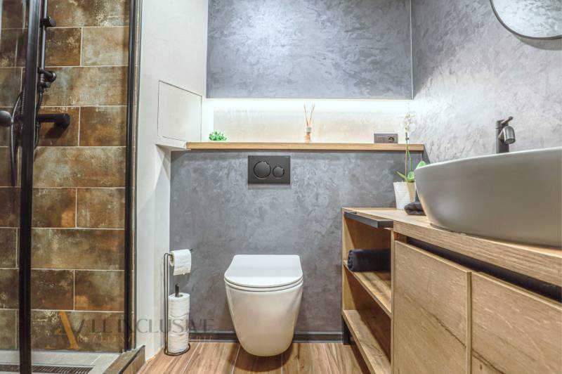 Badezimmer in einer 3-Zimmer-Wohnung mit Toilette, Waschbecken und Duschkabine.