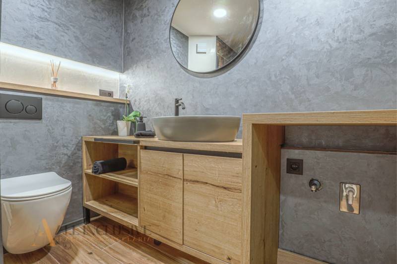 Badezimmer in einer 3-Zimmer-Wohnung mit Holzmöbeln und moderner Sanitärtechnik.