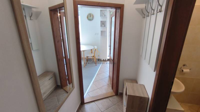 Flur einer 2-Zimmer-Wohnung mit Garderoben, Spiegel und Blick auf den Essbereich.