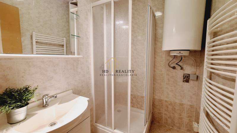 Badezimmer in einer 3-Zimmer-Wohnung mit Duschkabine und Wassererhitzer.