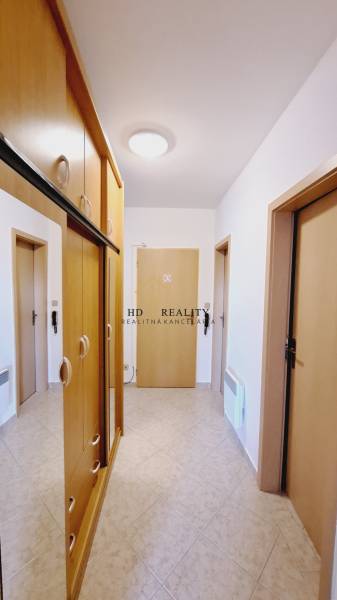Diele in einer 3-Zimmer-Wohnung mit eingebauten Holzschränken und Keramikfliesen.