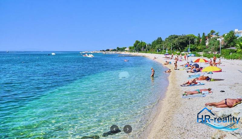 Der Strand in Novalja mit Touristen, die sich am Meer entspannen.