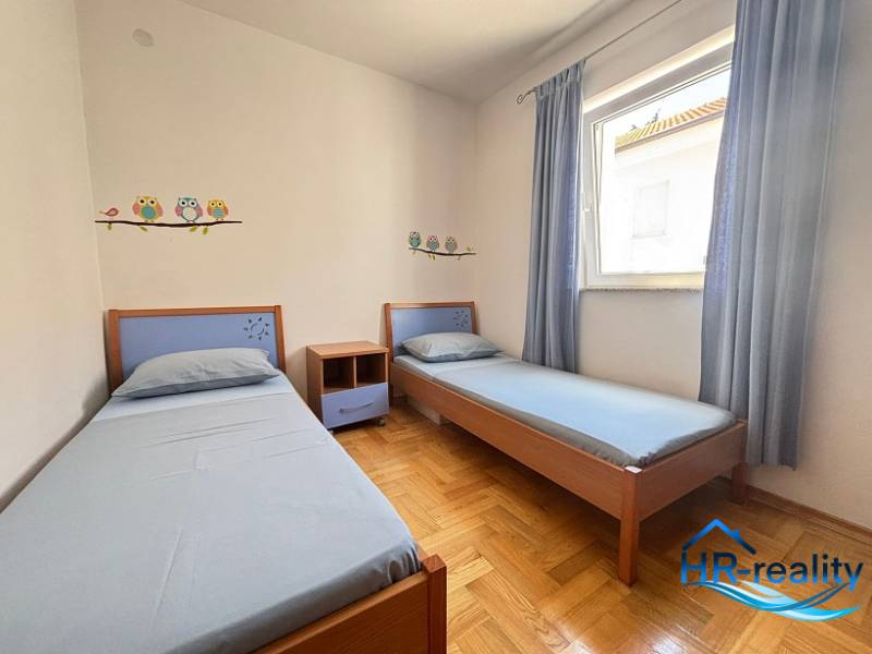 Kinderzimmer mit zwei Betten in einer Zweizimmerwohnung, dekoriert mit Eulenaufklebern.