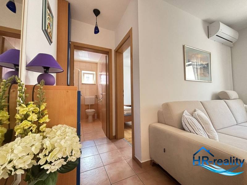 Helle 2-Zimmer-Wohnung mit bequemer Couch und Badezimmer mit Zugang vom Flur.