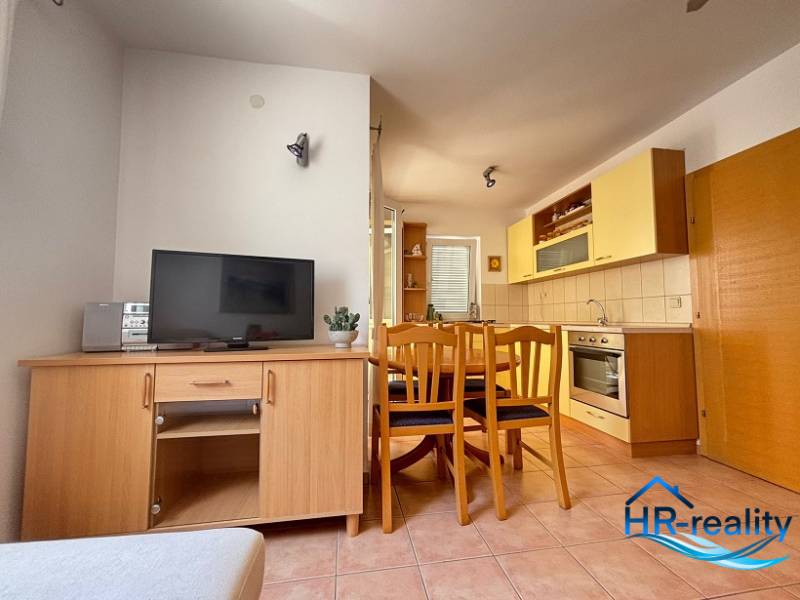 Küche mit Essbereich in einer 2-Zimmer-Wohnung, eingerichtet mit Holzmöbeln und Geräten.