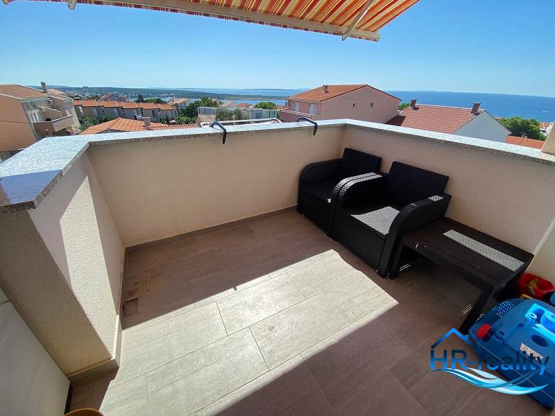 Zweizimmerwohnung in Novalja, Terrasse mit Meerblick, zwei Sessel, Tisch.