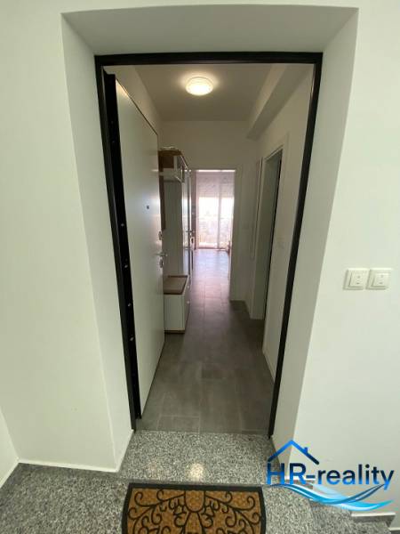 Eingangsbereich einer 2-Zimmer-Wohnung, mit Fliesenboden und Beleuchtung.