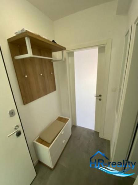 Der Flur einer 2-Zimmer-Wohnung mit Garderobe, Schuhschrank und weißen Wänden.