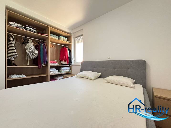 Schlafzimmer mit Doppelbett und Kleiderschrank in einer 2-Zimmer-Wohnung.