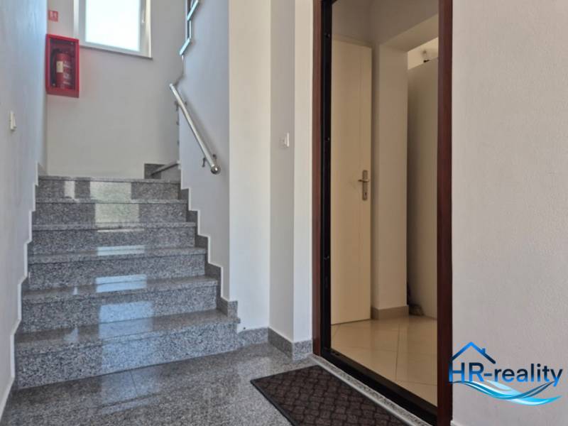 Eine saubere Treppe mit offenen Türen in einer 2-Zimmer-Wohnung mit Marmorboden.