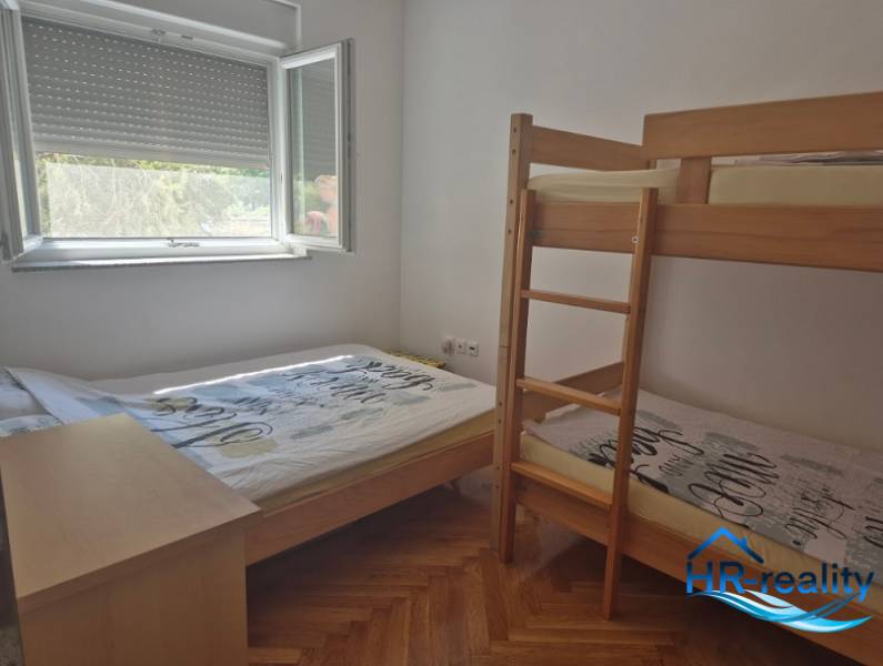 Schlafzimmer in einer 2-Zimmer-Wohnung mit einem Etagenbett und einem Einzelbett.