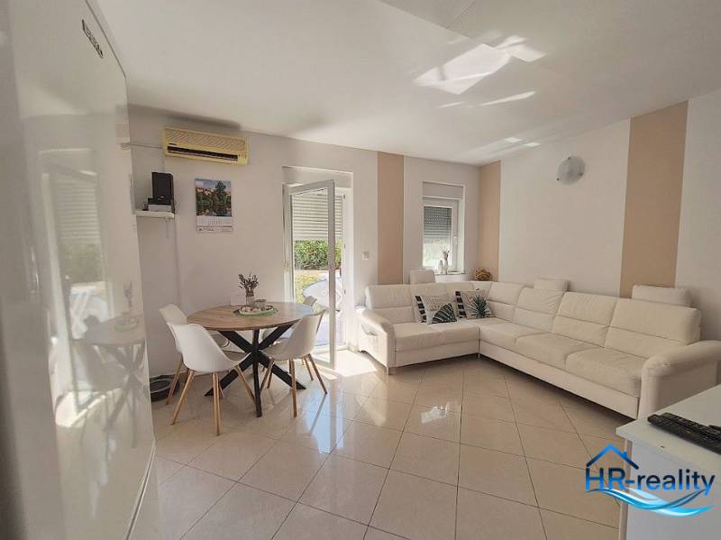 Helles Wohnzimmer in einer 2-Zimmer-Wohnung mit weißem Sofa und Esstisch.