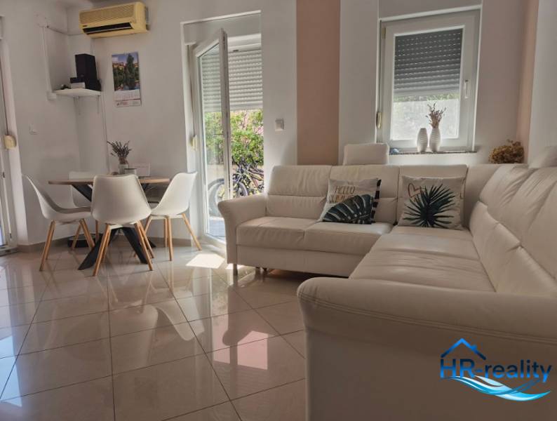 Helles Wohnzimmer in einer 2-Zimmer-Wohnung mit weißem Sofa und Esstisch.
