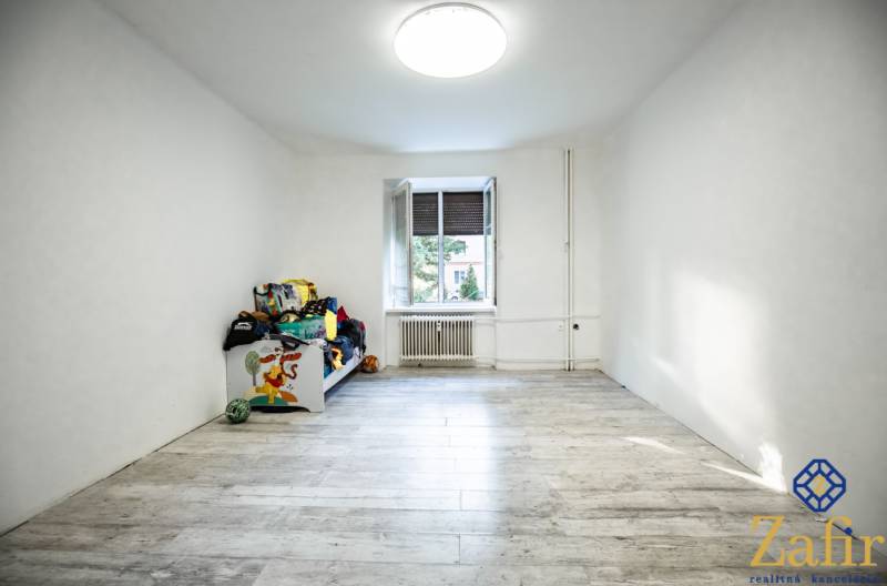 Ein geräumiges Zimmer mit einem Einzelbett und einem großen Fenster in einer 3-Zimmer-Wohnung.