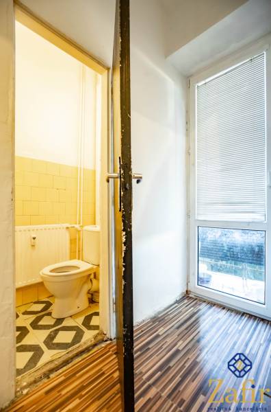 Badezimmer in einer 3-Zimmer-Wohnung mit Holzboden und Toilette.