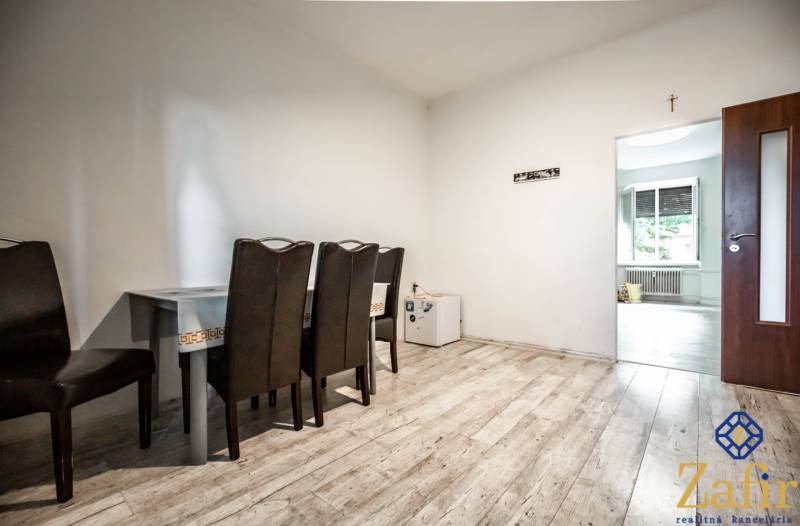 Esszimmer mit dunklen Stühlen und Tisch in einer 3-Zimmer-Wohnung.