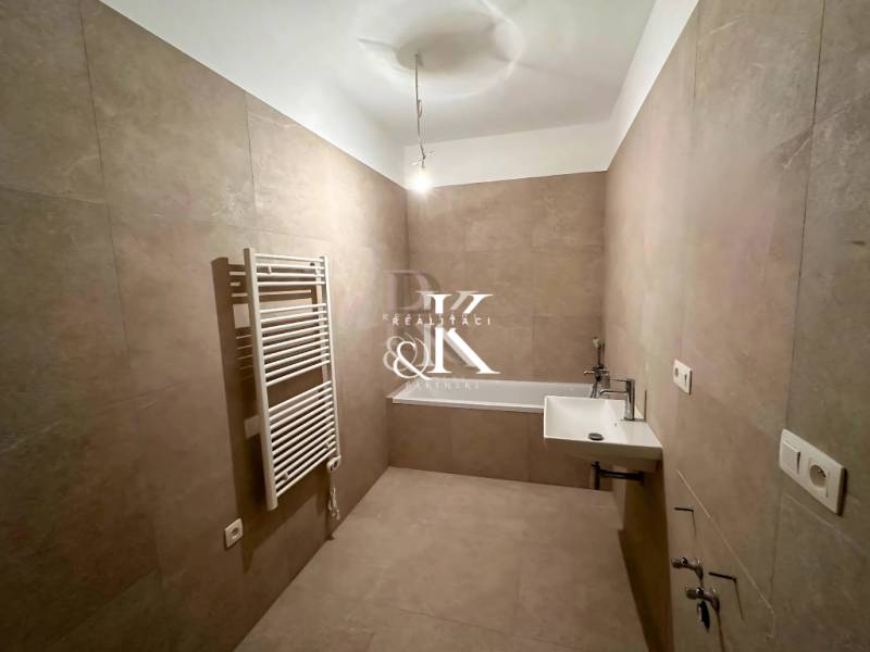 Badezimmer in einer 3-Zimmer-Wohnung mit Waschbecken, Badewanne und Röhrenheizkörper.