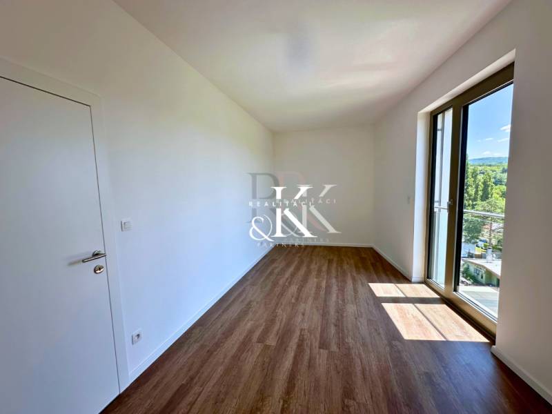 Ein Zimmer mit Holzboden und großem Fenster in einer 3-Zimmer-Wohnung.