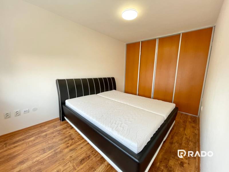Schlafzimmer mit großem Bett und Einbauschrank in einer 2-Zimmer-Wohnung.