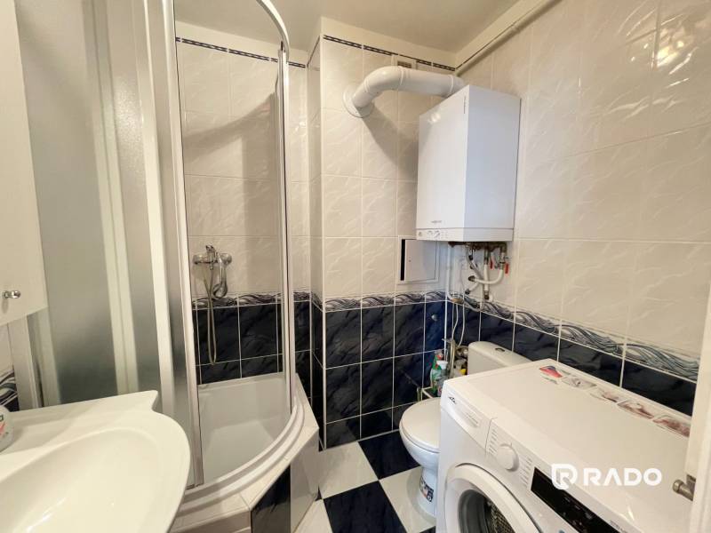 Badezimmer in einer 2-Zimmer-Wohnung mit Dusche, Waschmaschine und Gaskessel.