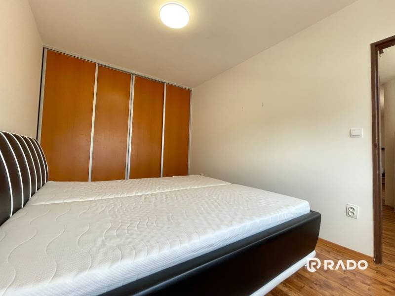 Schlafzimmer in einer 2-Zimmer-Wohnung, mit einem großen Bett und einem Einbauschrank.