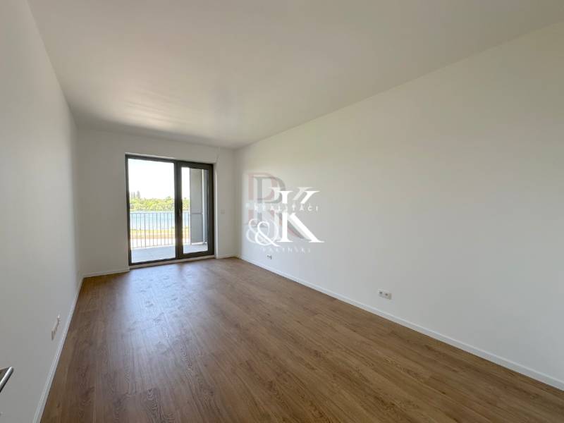 Geräumiges Zimmer in einer 2-Zimmer-Wohnung mit Holzboden und französischem Fenster.