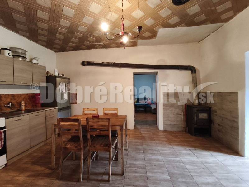 Küche in einem Einfamilienhaus mit Holzdecke, Tisch und Herd.