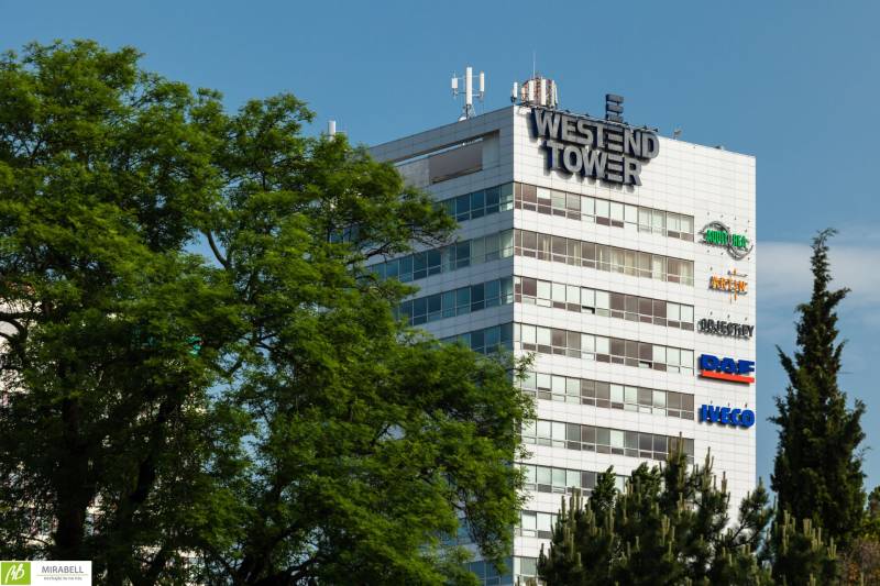 Das Westend Tower-Gebäude zwischen den Bäumen an der Dúbravská-Straße in Bratislava - Karlova Ves.