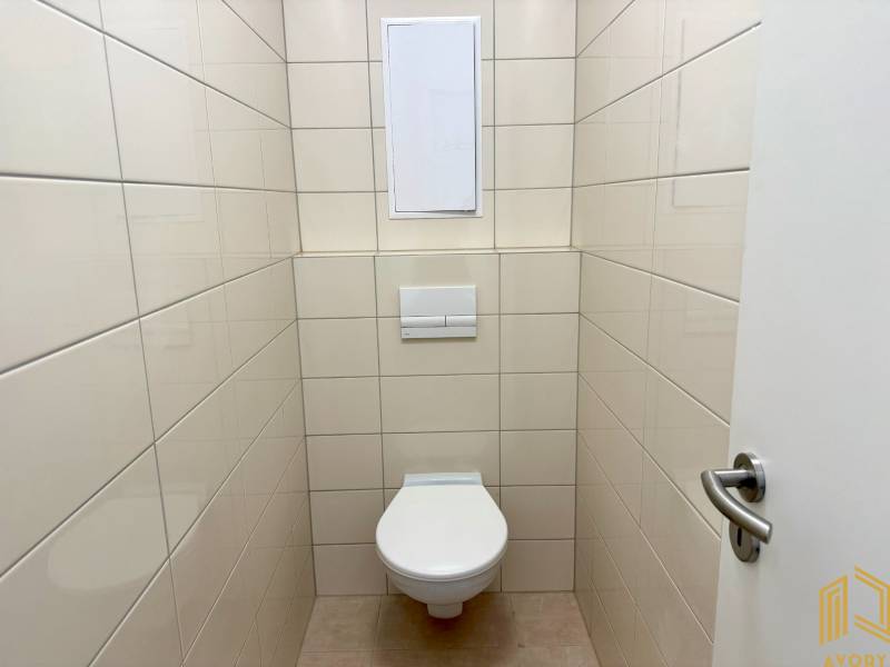 Toilette mit Fliesen in einer 2-Zimmer-Wohnung, helle Fliesen.