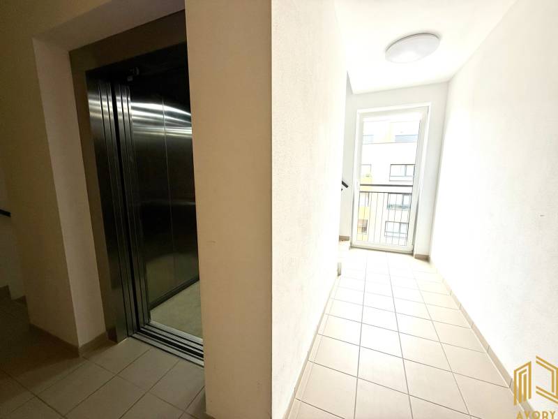 Ein Flur mit hellem Belag und einem Aufzug in einer 2-Zimmer-Wohnung.