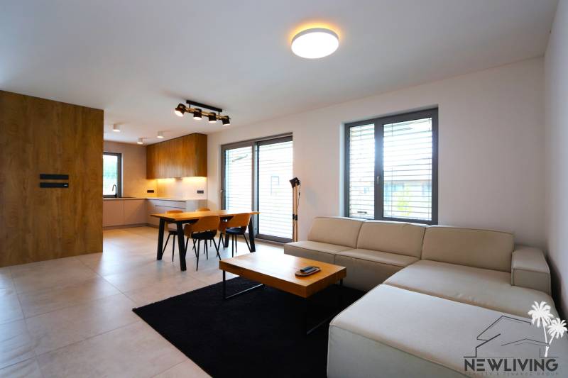Wohnzimmer mit Küche, Esstisch, Sofa und Holzelemente in einem Einfamilienhaus.